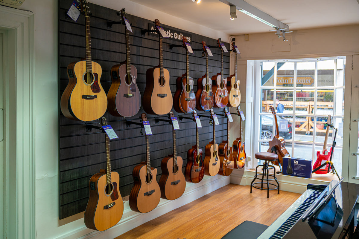 Acoustic guitars displayed beside the front window at Cirencester Music Academy