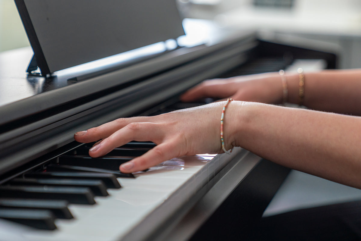 Close-up of hands playing piano keys at Cirencester Music Academy