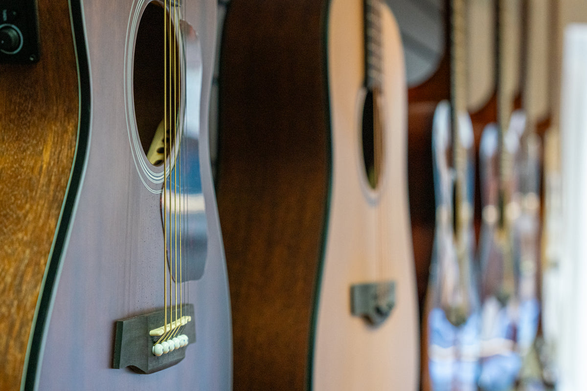 Close-up of acoustic guitars displayed in the music shop